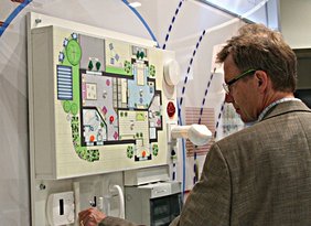 Mann vor einem Modell eines Smart Home