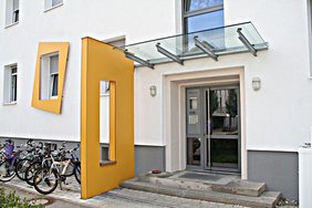 Eine gelbe Haustür mit Fahrrädern neben dem Eingang