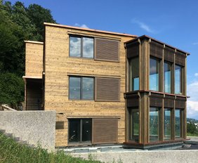 Haus mit Holzfassade und Vakuumglas-Fensterfronten