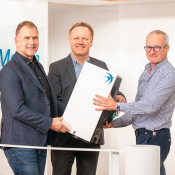 Bernhard Martin übergibt symbolisch das neue Lüftungsgerät an Geschäftsführer Thomas Schally und Dr. Reiner Borsdorf. Foto: bluMartin GmbH